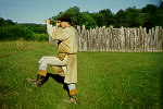 Re-enactor looking through spyglass outside Fort Necessity