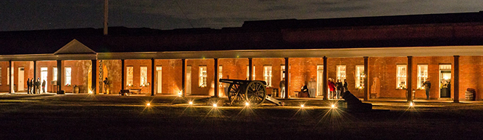 Cannon Sit on the Parade Ground of Fort Pulaski illuminated by candlelight.