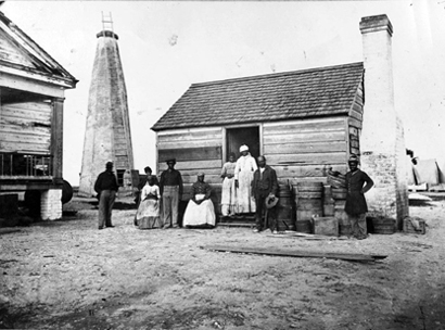 Family in front of cabin, Cockspur Island