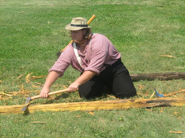 Reenactor Hewing a Log