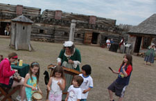 girls stand in a a group in an open ground playing old fashioned musical instruments.