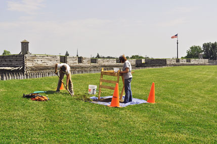 Archeologists dig outside the reconstructed fort
