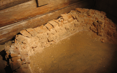 a softly lit brick hearth foundation sits in a wooden and glass enclosure
