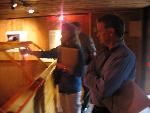 three people stand around a wooden and glass box
