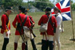 men in bright red coats near a blue and red flag
