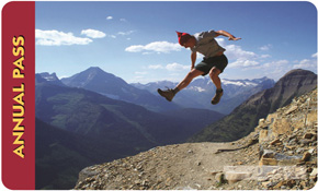 Federal Lands Pass 2012: a man jumps from a mountain cliff and seems to pause against a blue silouette of peaks