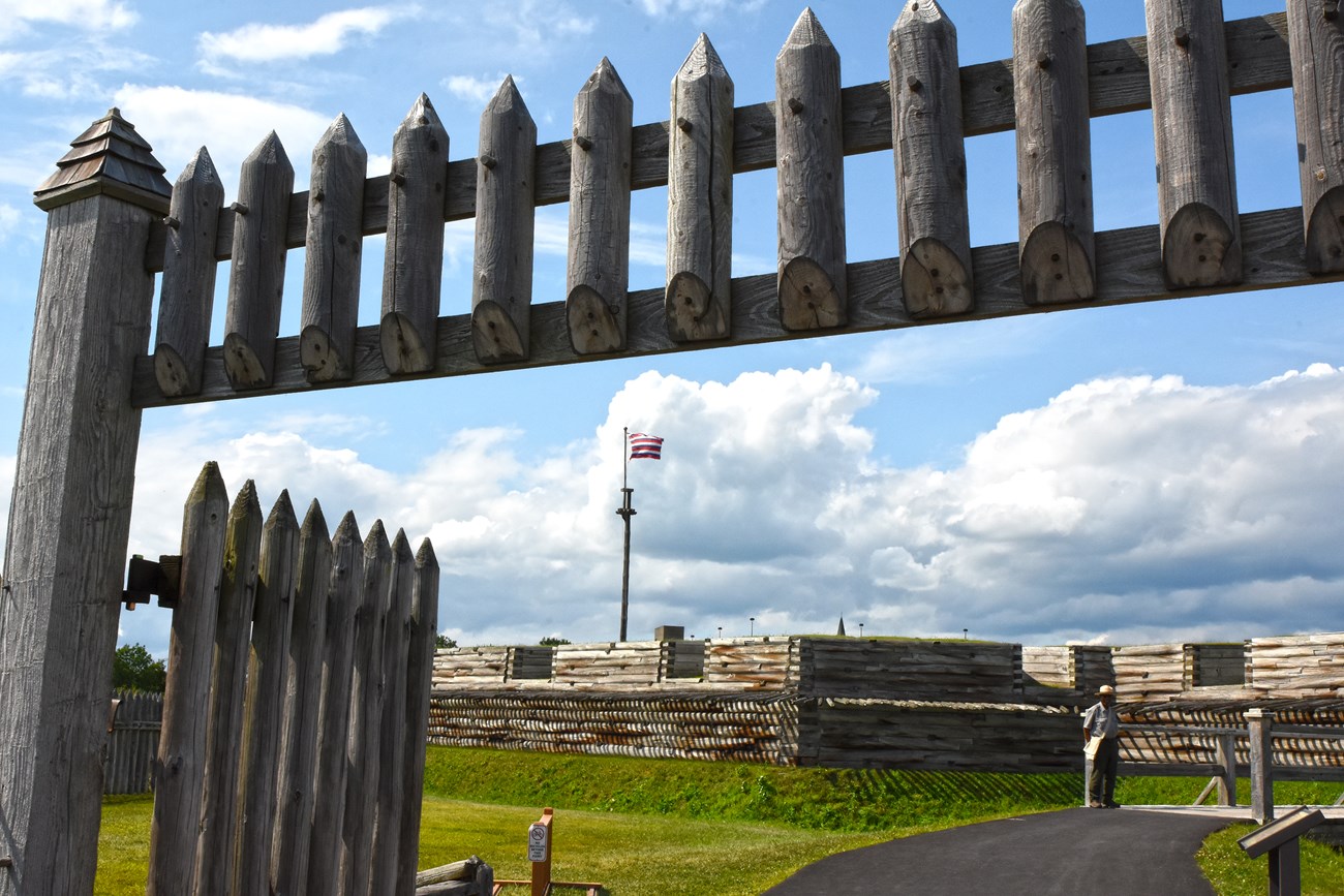 A wooden picket gate over the head of the viewer. The fort walls are behind it.
