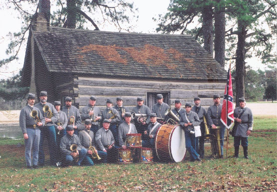 Members of the 8th Georgia Band pose in front of a log cabin in Danville, Kentucky