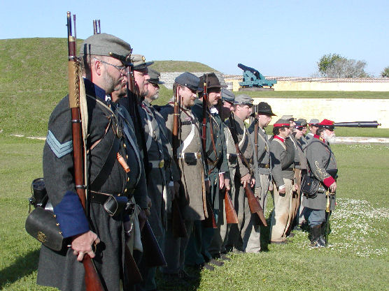 Several men in Civil War uniform with muskets.