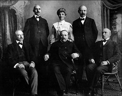 Ilfeld family standing and sitting around parlor table