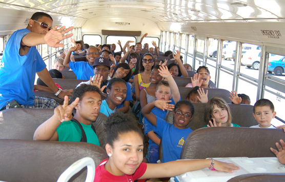 Youth arrive on a bus at Fort Vancouver and wave