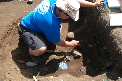Field School student excavating a trash pit