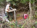 NCRI Archaeologist Beth Horton screens for artifacts in rough terrain at Lewis and Clark National Historical Park