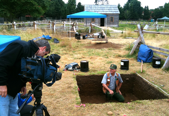 Dr. Douglas Wilson describes an archaeology dig for news cameras while sitting in an excavation pit in the Fort Vancouver Village.