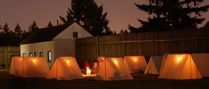 Tents glow in the evening of an 1840s Overnighter