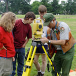 Archaeologist instructing students in the operation of surveyorr's equipment