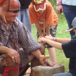American Indian re-enactor demonstration historic fire-starting techniques to young boy