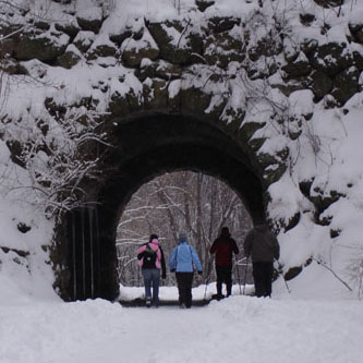 X-country skiers passing through Ellicottdale Arch 