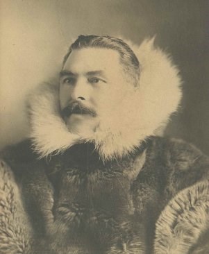 Historic photo of Gordon Bettles wearing an elaborate fur coat with an oversized ruff.