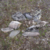 An old campfire scar and rock ring on the tundra.
