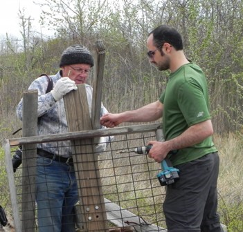 Volunteers Don Riepe and Shervin Hess build an osprey platform out of wood salvaged at the salt marsh.