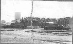 Soldiers pose with gun at roundhouse, c. 1910
