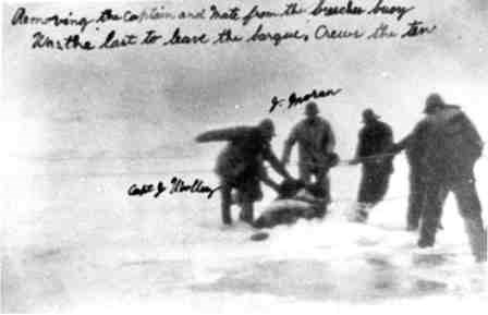 Another photo of the rescue of the captain of the Edmund J. Phinney. Inscribed message says, "Removing the Captain and Mate from the breeches buoy / Was the last to leave the barque [watercraft], Crews the ten [a crew of ten]"
