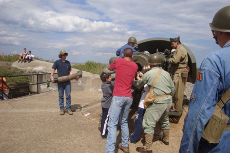 The public helps volunteers from Army Ground Forces Association to load the six inch gun at Battery Gunnison