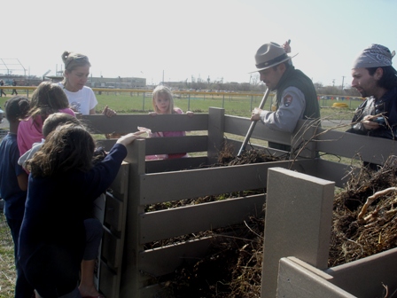 A Gateway park ranger helps students in RAA's after-school program learn how to compost garbage. Photo courtesy of RAA.