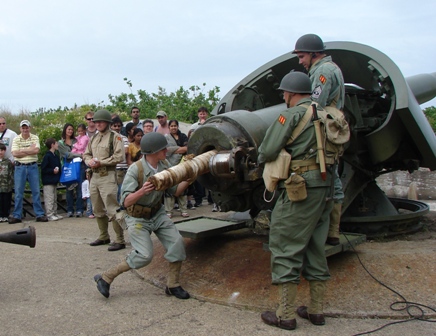 Visitors watch as volunteers from the Army Ground Forces Association load the gun at Fort Hancock's Battery Gunnison.