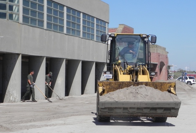 Maintenance employees at Gateway shovel sand at Jacob Riis Park, getting the park safe to reopen.