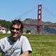 male volunteer in grassy field with Golden Gate Bridge in background