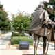 bronze Gandhi statue overlooking walkway and garden