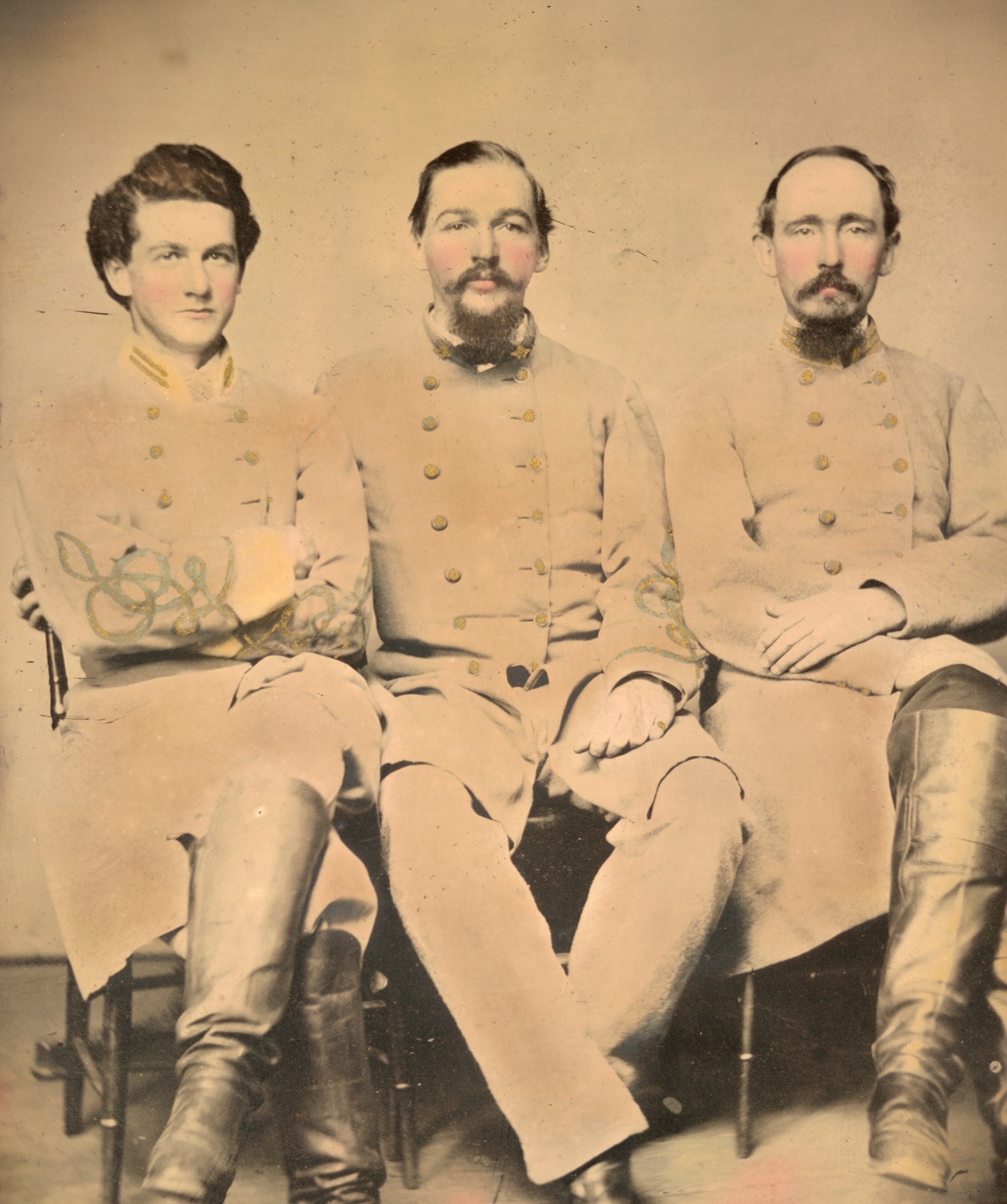 Three Confederate soldiers posing for a picture in uniform.