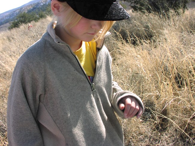 A close-up of a student walking through a field.