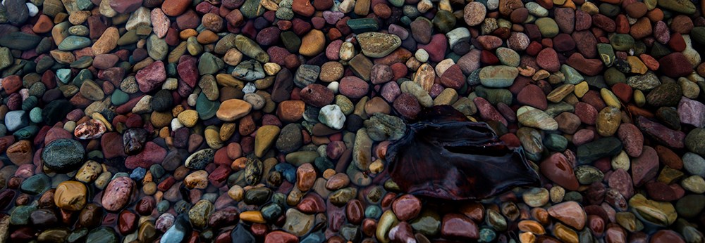 close-up of many colored rocks below water surface