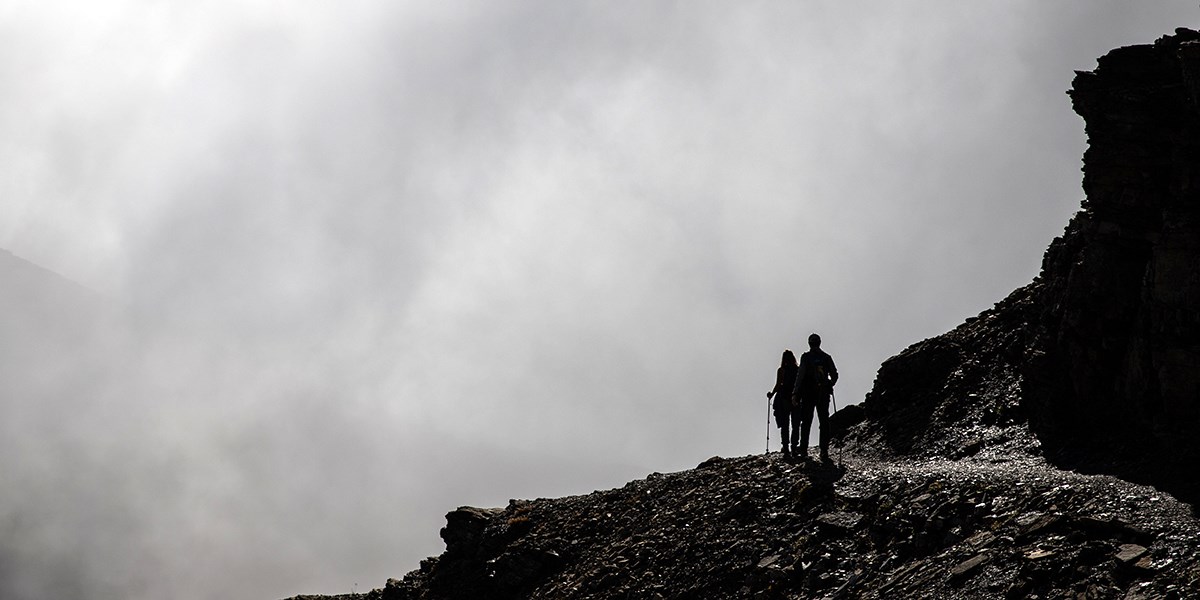 Hikers on the Highline Trail walking into a cloud bank