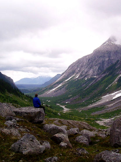 Backpacker looks down river valley