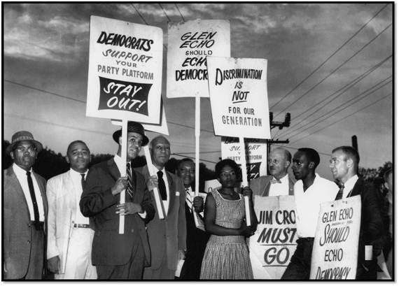 Protest signs with black and white group members plus Gwendolyn Britt