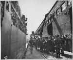 Troops loading ships at Fort Mason while a band plays, c1940s