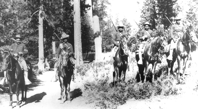 photo of African-American soldiers on horseback in a grove of trees
