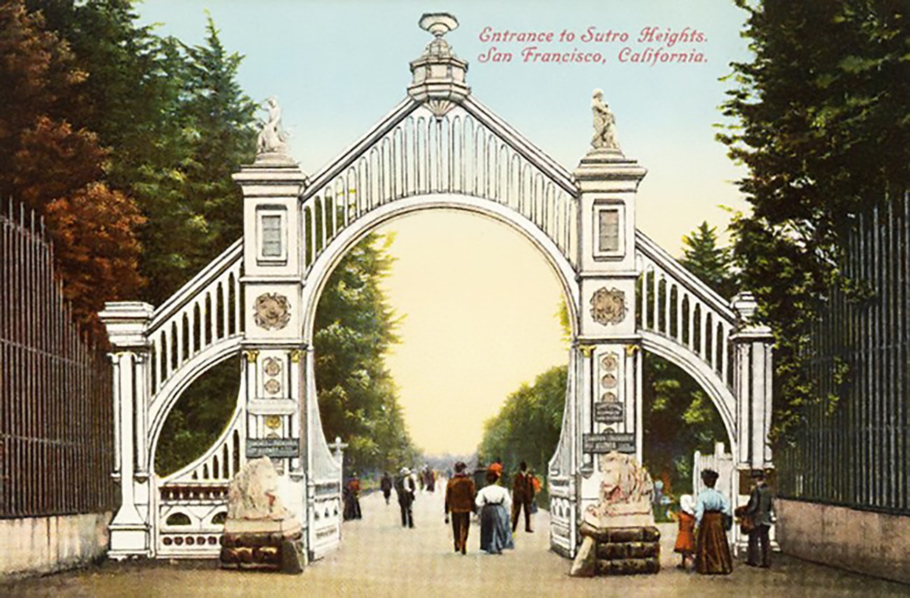 Historic colored postcard of ornate garden gate with people entering.