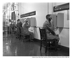 Visitors and lawyers using phones in the visitation room on Alcatraz.