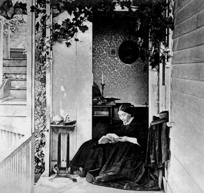 historic photo of Jessie Benton Fremont sitting and reading on her front porch