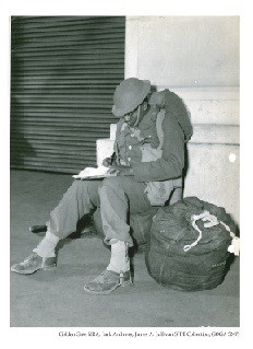 Private Joe Fleming, New York City, catching up on his book work as he awaits embarkation.