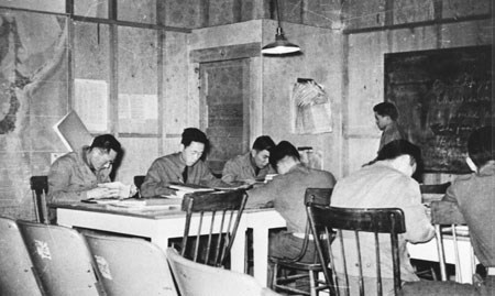 historic photo of Nisei soldiers sitting and studying at tables inside a historic building
