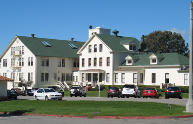 Photo of Golden Gate National Recreation Area headquarters building, painting in presidio white with a green shingled roof.