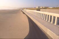 A picture of the sand banked up against the wall of ocean beach.