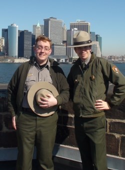 Rangers Adam and Greg on the roof of Castle Williams, with Manhattan's Financial District in the background.
