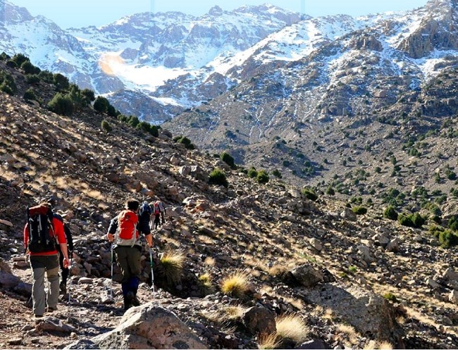 Several visitors hiking through trails in the mountains of Toubkal National Park